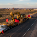 Oversized excavator being transported on heavy haul trailer with GPS tracking for real-time visibility